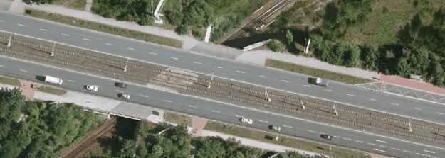 Na leteckém snímku vidíme most převádějící Černokosteleckou ulici nad železniční vlečkou do areálu České pošty u tramvajové zastávky Depo Hostivař.
