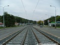 Tramvajová trať klesá v otevřeném svršku od zastávky Poštovka ve středu Plzeňské ulice, v dálce již vidíme blížící se pravý oblouk