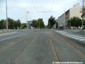 Na zvýšeném tělese ve středu ulice Jugoslávských partyzánů pokračuje tramvajové trať krytá asfaltovým krytem.