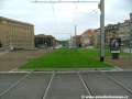 Přímý zatravněný úsek tramvajové tratě v místě někdejší smyčky Podbaba.