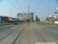 Přejezd tramvajové tratě pro automobily na úrovni vyústění Nademlejnské ulice, za nímž se koleje začínají stáčet v táhlém pravém oblouku a stoupají.