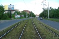 Táhlý zatravněný pravý oblouk tramvajové tratě ve středu Průběžní ulice.