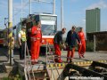 Pracovníci technické kontroly přinášejí vyztuženou spojovací tyč určenou k vytažení vozu. | 23.5.2007