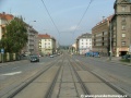 Tramvajová trať na zvýšeném tělese tvořeném velkoplošnými panely BKV klesá středem Svatovítské ulice.