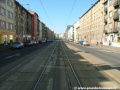 Přímý úsek tramvajové tratě zřízené velkoplošnými panely BKV na zvýšeném tělese ve středu ulice V Olšinách.