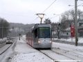 Za husté sněhové vánice míří Plzeňskou ulicí k vozovně Motol vůz Škoda 14T ev.č.9117, již s umáznutým evidenčním číslem vepsaným do sněhu na jeho čele, jedoucí za krycím vlakem u vozů T6A5 ev.č.8713+8714. | 27.1.2007