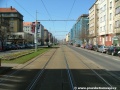 Přímý úsek tramvajové tratě zřízené velkoplošnými panely BKV ve středu Vršovické ulice.