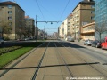 Přímý úsek tramvajové tratě zřízené velkoplošnými panely BKV ve středu Vršovické ulice.