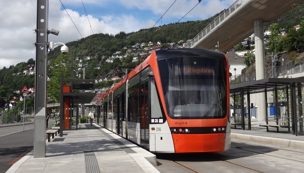 Stadler Variobahn #216 na lince 2 odbavuje cestující v zastávce Floen. Most vpravo nahoře je pěší a cyklistická lávka, která spojuje různě vysoko položené části města. | 12.7.2023